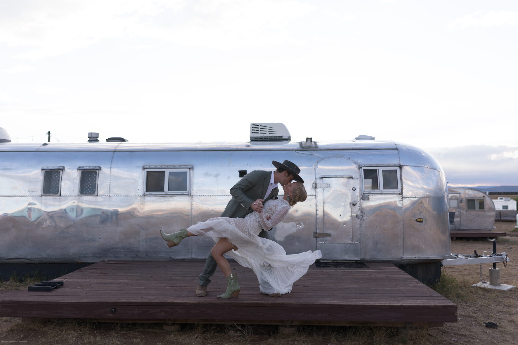 Couple kissing in front of Airstream trailer, before Sol Dorado